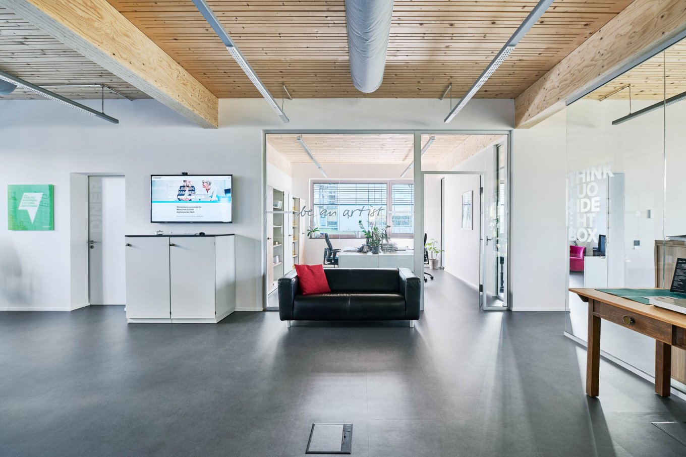 wineo PURLINE Bioboden im Büro dunkle Fliesen Fußboden Bodenbelag Sofa moderne Einrichtung Agentur
