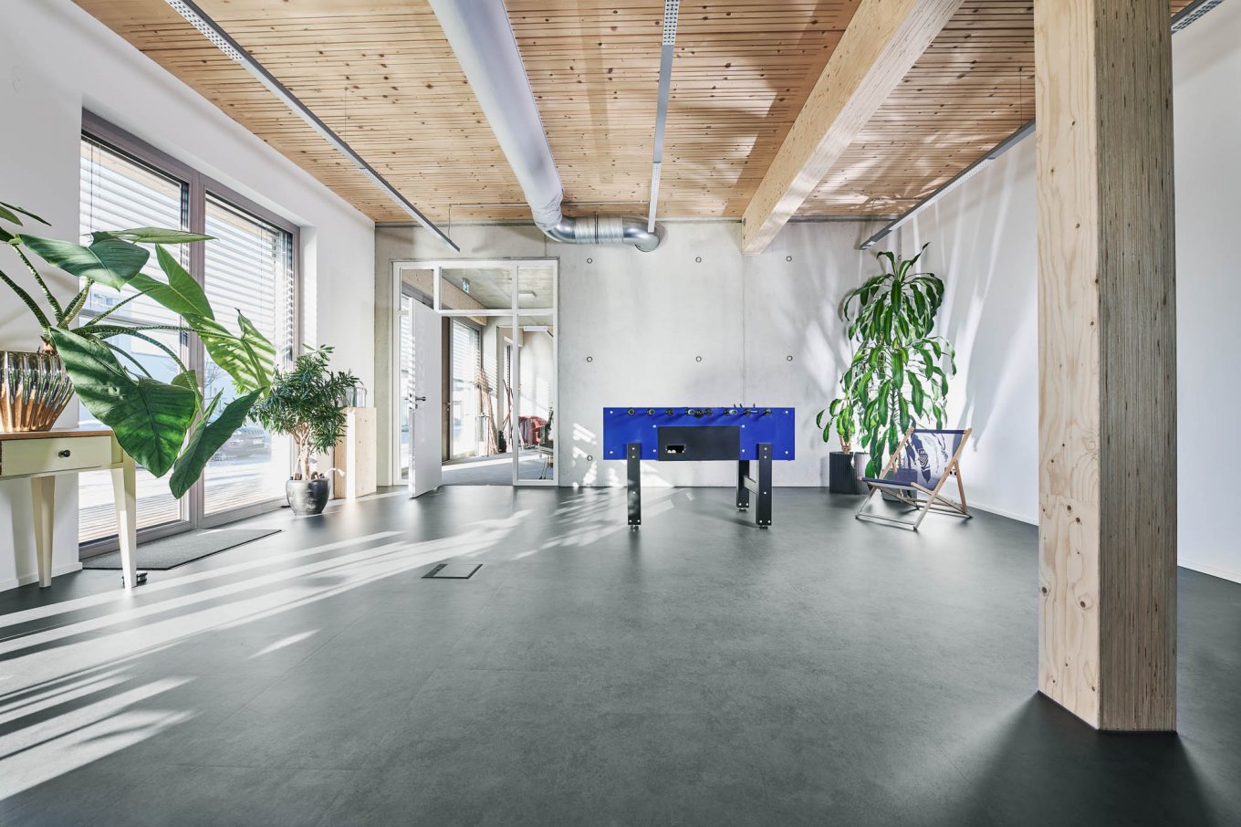 wineo PURLINE Bioboden im Büro dunkle Fliesen Tischkicker Kickertisch Zimmerpflanze Grünpflanze Fußboden Bodenbelag