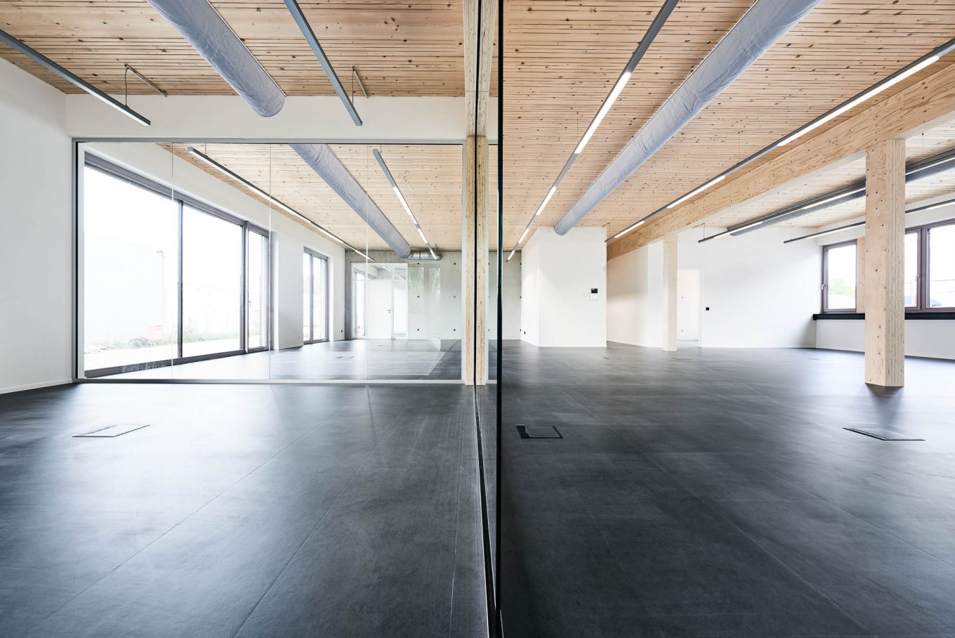 wineo PURLINE Bioboden dunkle Fliesen im Büro Holzdecke Loft Style tiefe Fenster Fußboden