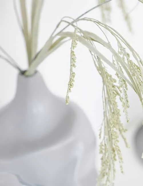 Moderne weiße Vase mit Deko-Pflanze 